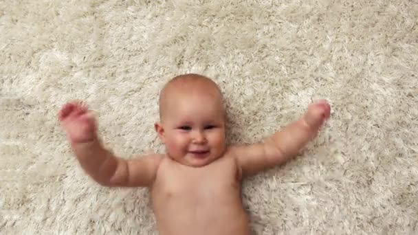 Happy Baby Swinging His Arms Touching His Hair Lying Soft — Stock Video