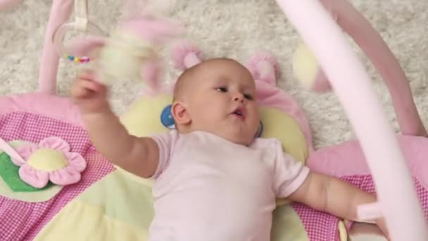Süßes Mädchen Liegt Auf Teppich Und Spielt Mit Spielzeug — Stockvideo
