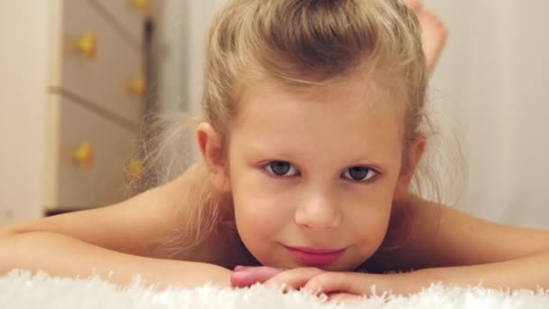 Милый Ребенок Улыбается Красивая Маленькая Девочка Лежит Полу Отдыхает Помещении — стоковое видео