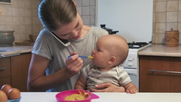 Kleines Kind Isst Püree Und Schaut Baby App Auf Smartphone — Stockvideo