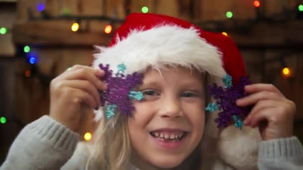 Симпатична Маленька Дівчинка Санта Грає Сніжинками Фоні Різдвяних Вогнів — стокове відео