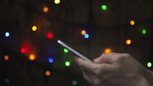 Close Female Hands Texting Message Her Smartphone Festive Colorful Lights — Stock Video