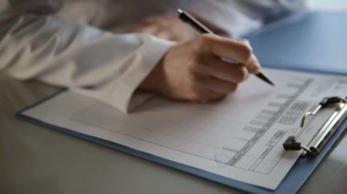 Ofiste çalışan kadın doktor tıbbi Belge imzalama.