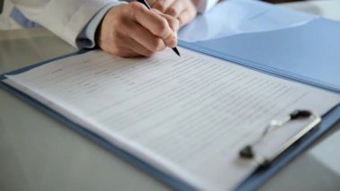 Kadın terapist klinikte masasında tıbbi rapor yazma.