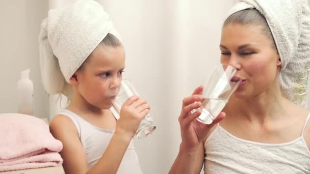 うれしそうな愛する家族 母と娘の寝室でお風呂の後純粋な水を飲む — ストック動画