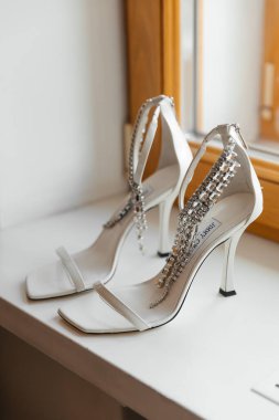 Dubai BAE 08 Eylül 2025: Doğal ışık iç mekan temalı zarif beyaz Jimmy Choo ayakkabıları. Yüksek kalite fotoğraf