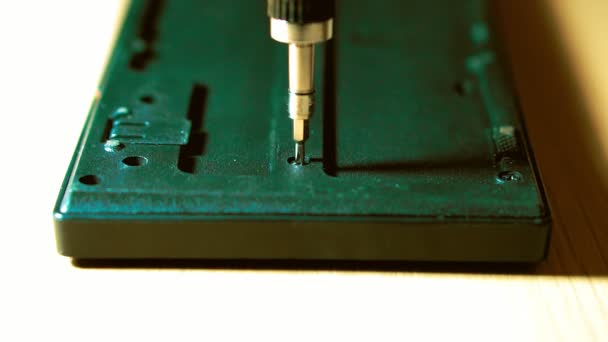 Close-up van een hand die draai de schroef. In de handen van een schroevendraaier met verwisselbare sproeiers. toetsenbord — Stockvideo