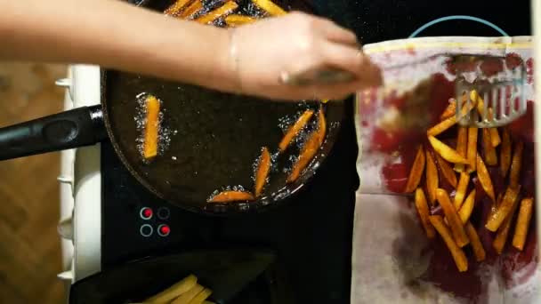 Primo piano di mani che preparano patatine fritte. Le patate fritte si mettono un piatto con un tovagliolo . — Video Stock