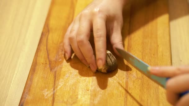 Cutting mushrooms in the kitchen. Light wooden table. — Stock Video