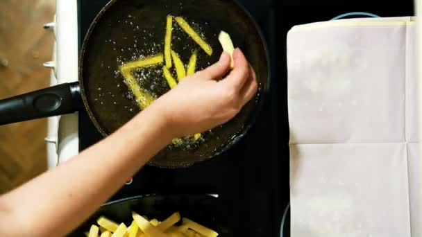 Nahaufnahme von Händen, die Pommes zubereiten. die Scheiben in eine Pfanne legen. — Stockvideo