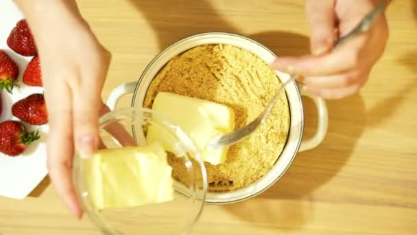 Cozimento caseiro. A base da torta. Bolachas trituradas. Adicione um pedaço de manteiga . — Vídeo de Stock