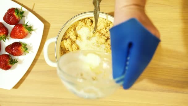Hausgemachtes Backen. die Grundlage des Kuchens. zerquetschte Kekse. Etwas Milchcreme hinzufügen. gründlich umrühren. — Stockvideo