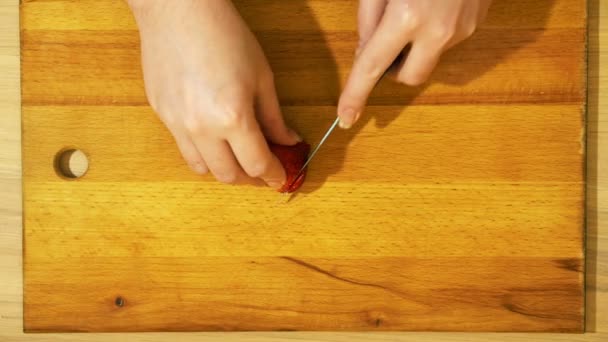 Tagliare le fragole in cucina. Tavolo in legno chiaro . — Video Stock