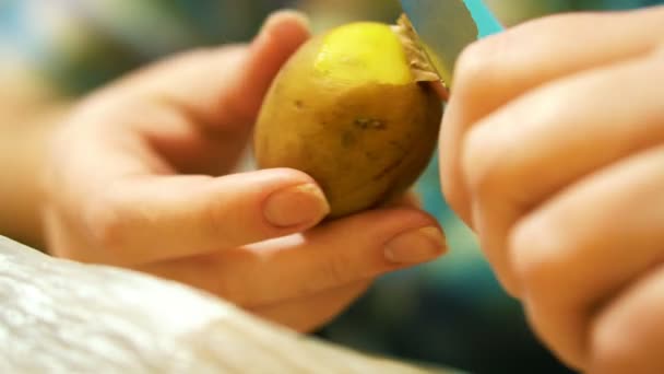 Närbild av en hand peel potatis. Kniv i handen på kocken. — Stockvideo