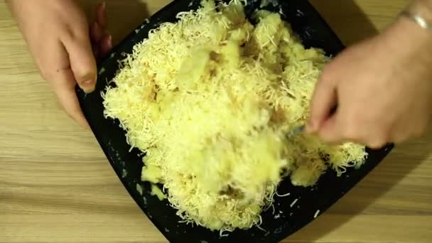 Mashed potatoes in a cup. Put the crushed cheese. Stir gently. — Stock Video