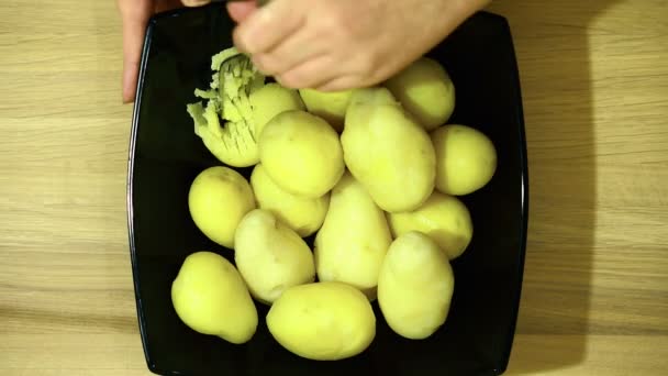 De gekookte aardappelen voorzichtig te slijpen met een vork. — Stockvideo