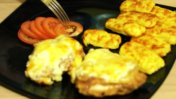 Une collation maison. Des bâtonnets de pommes de terre frites. Des morceaux de poulet au fromage. Nous essayons les bâtons avec une tomate fraîche . — Video