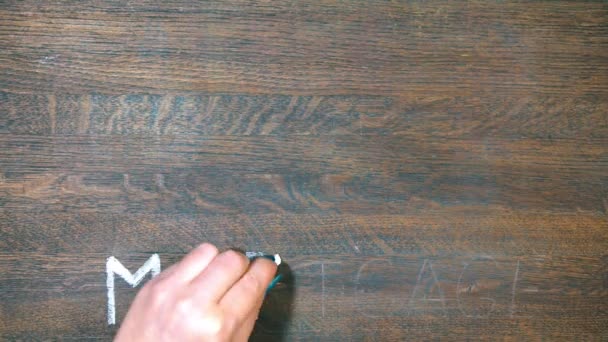 El primer plano de la mano dibuja en una tabla de madera. Dibujando la casa con tiza. Anuncio de hipoteca . — Vídeos de Stock