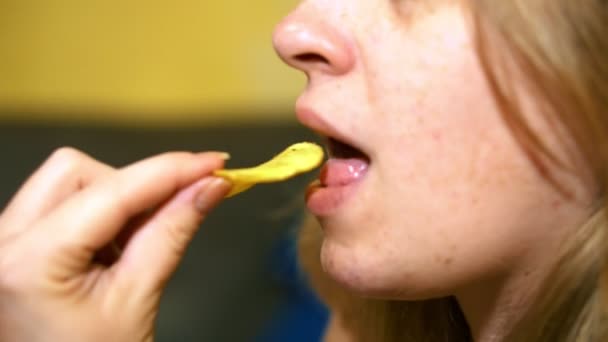 A menina está comendo deliciosos chips . — Vídeo de Stock