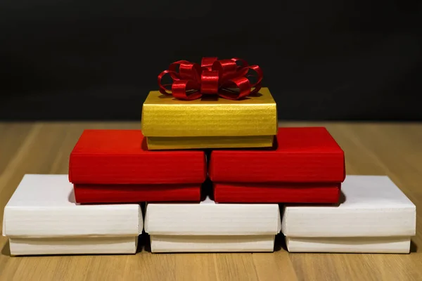 Composición de cajas festivas de color blanco, rojo y dorado sobre una mesa de madera . —  Fotos de Stock