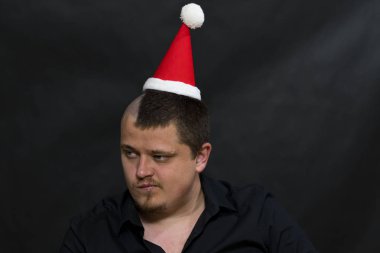 Serseri bir alt kültür olarak. Kafasında Noel şapka. İronik ifade.