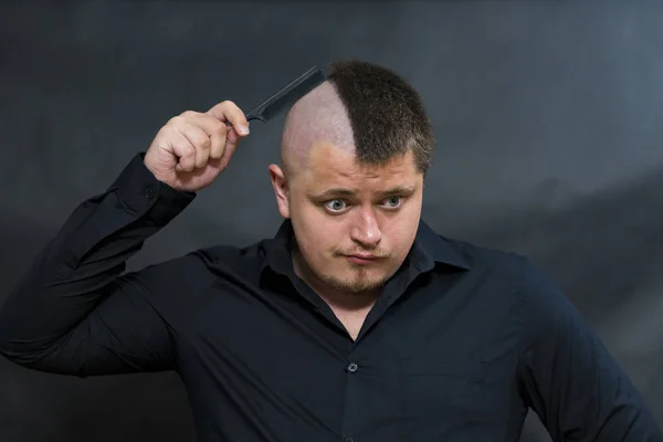 Idiota. En el peine para el pelo. Intenta según el hábito de peinarse el cabello. Una mirada de asombro . — Foto de Stock