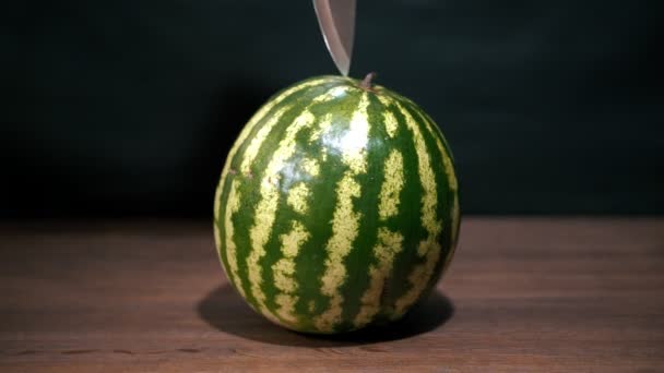 Een mes doorboort een watermeloen. — Stockvideo