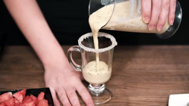 Smoothies. In ein Glas mit Zuckerrand gießen. eine Scheibe Kiwi am Rand des Glases. — Stockvideo