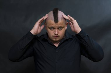 Siyah gömlekli bir mohawk ile punk. Parmak kafasına dokundum. Soran ve sert ifade.