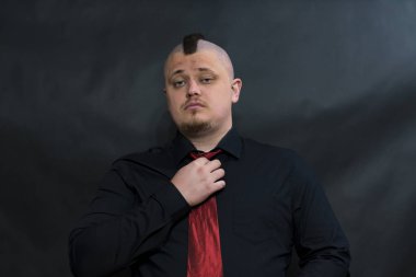 Alt kültür serseri. Iroquois. Lens arıyorum. Kırmızı kravat düzeltiyor. Ciddi ve memnun yüzüdür.