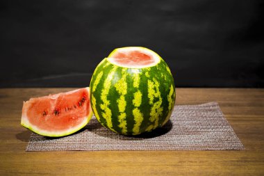 Ahşap bir masa üzerinde bir dilim karpuz. Küçük bir underripe.