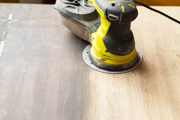 Manual electric grinding machine. It stands on the treated wooden surface. The trace of the polished strip is visible. — Stock Photo, Image