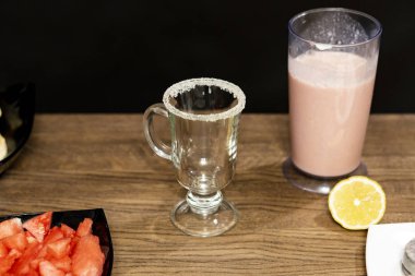 Ahşap bir masa üzerinde yaşam smoothies kokteyl. Siyah arka plan. Cam jant üzerinde şekerli. Bir dilim limon.
