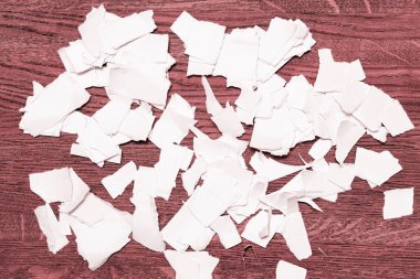 Kağıt pembemsi kahverengi ahşap zemin üzerinde yırtık artıkları.