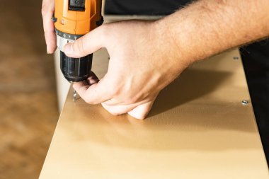 Bir matkap tutan el closeup. Öte yandan matkap dokunur.