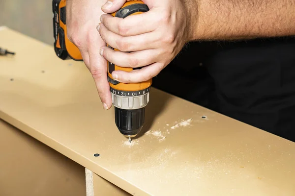 Build cabinet. Use an electric screwdriver to screw in the tapping screw. — Stock Photo, Image