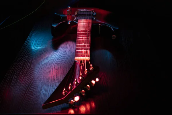 Elektrische gitaar op een houten tafel. Donkere achtergrond. — Stockfoto