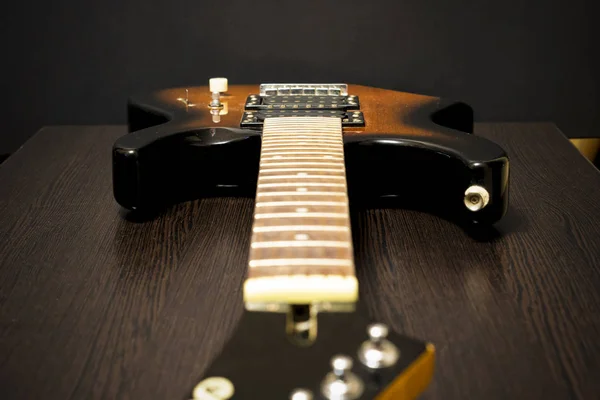Diapasón eléctrico de guitarra. Sobre el fondo de una mesa de madera. Faltan cuerdas. . —  Fotos de Stock