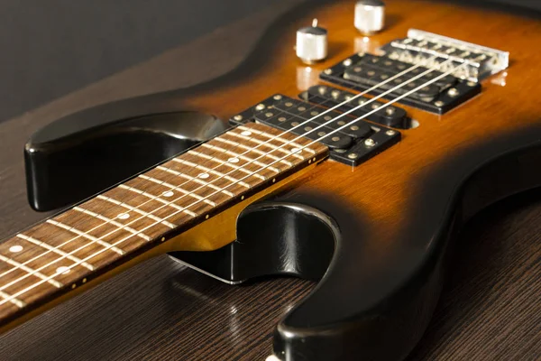 Guitarra eléctrica con seis cuerdas. Mesa de madera . —  Fotos de Stock