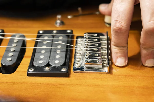 Bir elektro gitar standı ile dize yükleme Close-up. Vücudun parlak sarı yüzeyli.