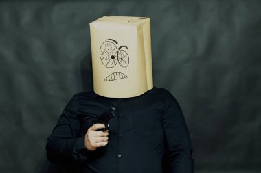 Duygu kavramı. Tehditkar ve odaklanmış haydut ifade. Elinde silahı.