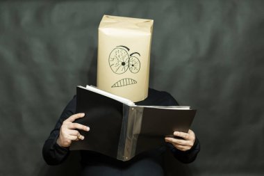 Duygu kavramı. Bir adam bir kitap okuyor. Yüz ifadesi odaklı ve özenli.