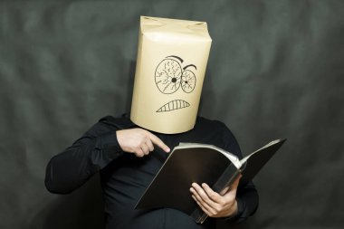 Duygu kavramı. Bir adam görünüyor ve bir kitapta bir parmağını gösterir. Yüz ifadesi sinirlenme ve memnuniyetsizlik.