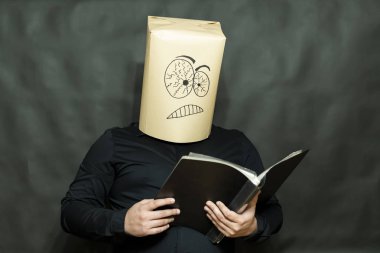 Duygu kavramı. Bir adam bir kitap okuyor. Odaklanmış ve tahriş olmuş yüz ifadesi.