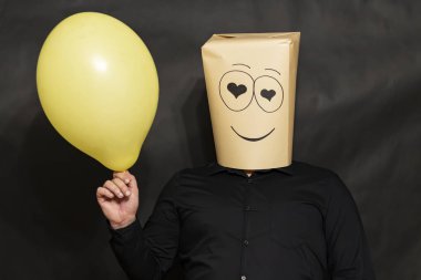 Duygular kavramı. Bir adam bir balon elinde tutuyor. Aşk gözünde görülür. Yüzünde bir gülümseme ve sevgi.