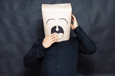 Duygular kavramı. Adam esniyor. İkinci kafa dokunur, sağ el ağız kapsar. Serenity ifadesidir. Arka planın gray bulanık olduğu.