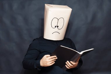 Duygu kavramı. Bir adam bir kitap okuyor. Odaklanmış ve sürpriz yüz ifadesi.