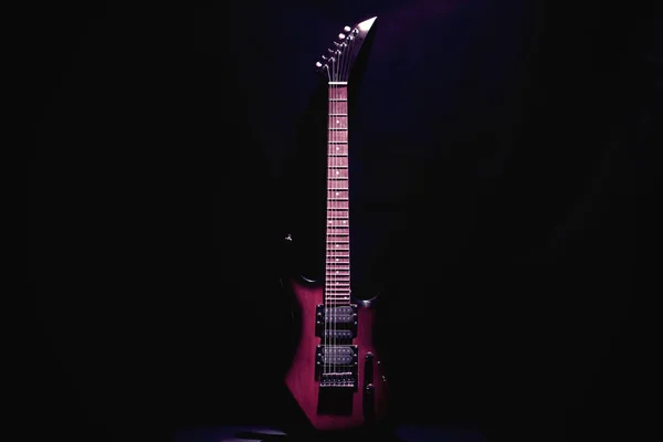 Röd elektrisk gitarr på en svart bakgrund. — Stockfoto