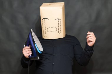 Duygu kavramı. Bir adam bir demir önünde tutar. Yüz, kızgınlık ve üzücü bir ifade üzerinde. Haddelenmiş gözyaşları.