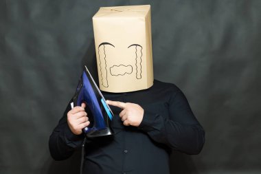 Duygu kavramı. Bir adam bir demir önünde tutar. Sol el parmak demir yüzeyine dokunduğundan. Yüz, kızgınlık ve üzücü bir ifade üzerinde. Haddelenmiş gözyaşları.